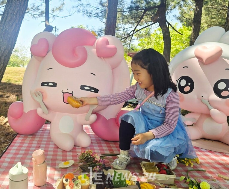 한 소녀가 박람회장에 설치된 티니핑에게 빵을 주면 웃고 있다. 백승일 기자 